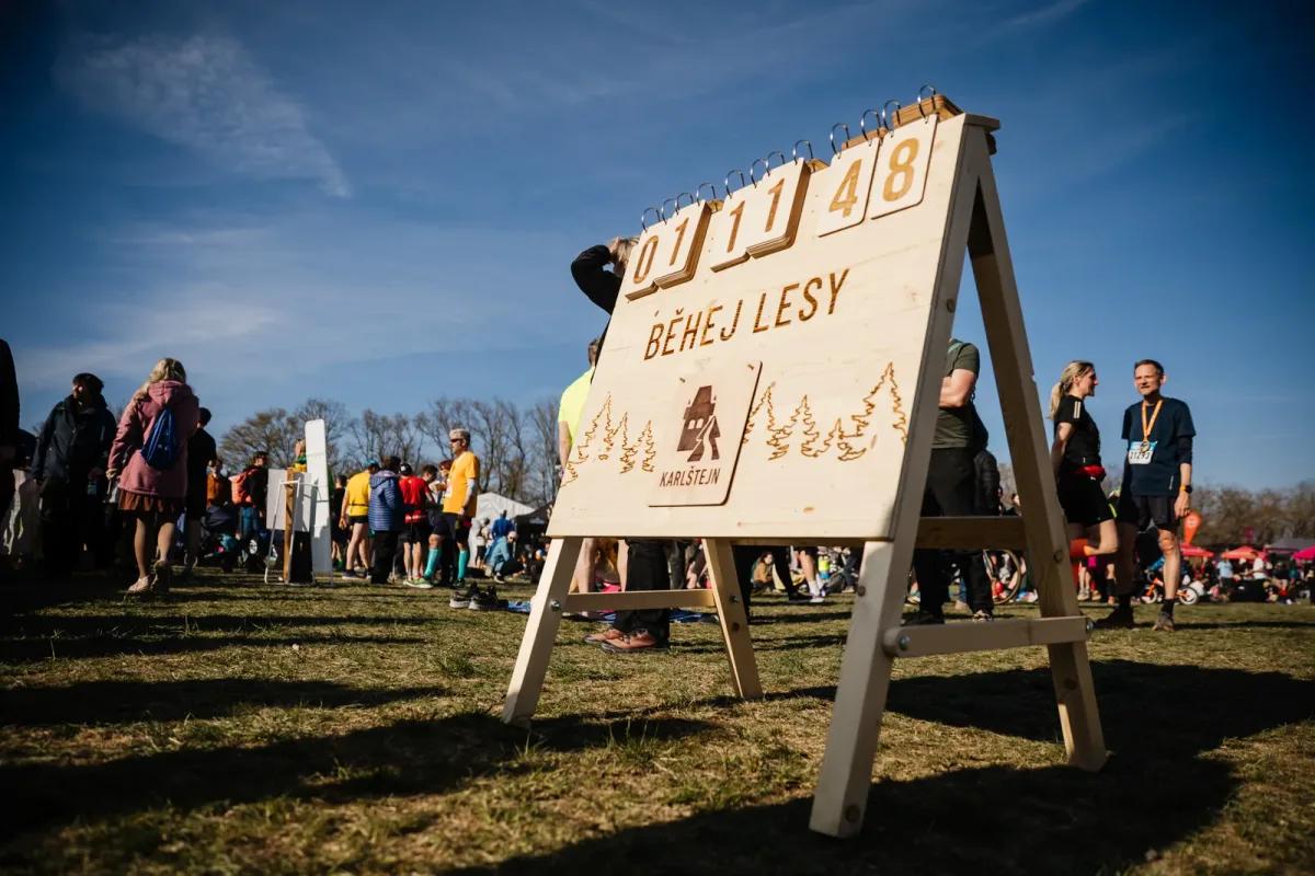 Dřevěná tabule Běhej Lesy s časomírou v cíli závodu